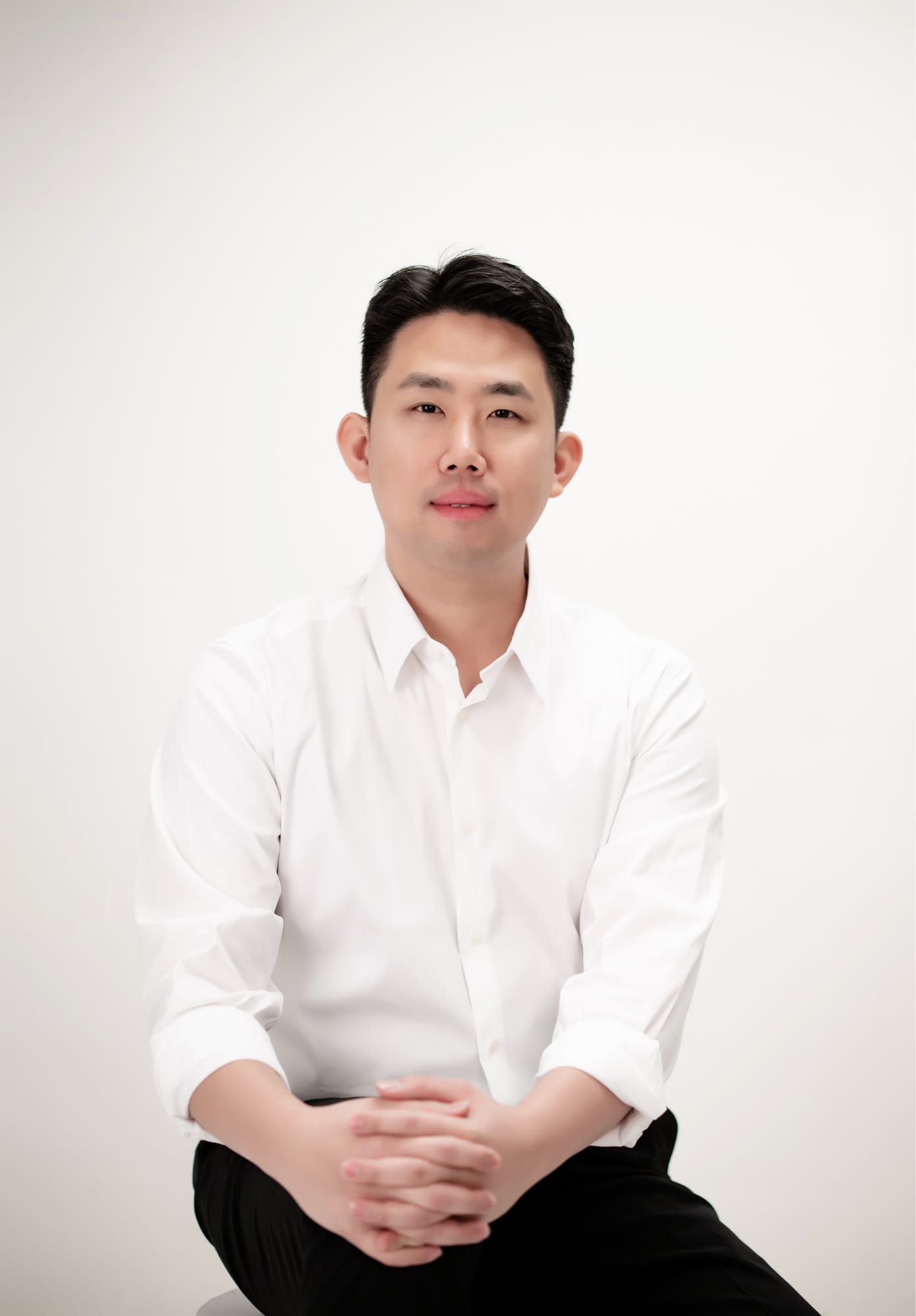 Portrait of the founder of not a chef., in a white shirt against a neutral background